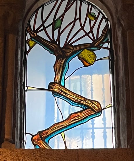 A stained glass window with a tree

Description automatically generated