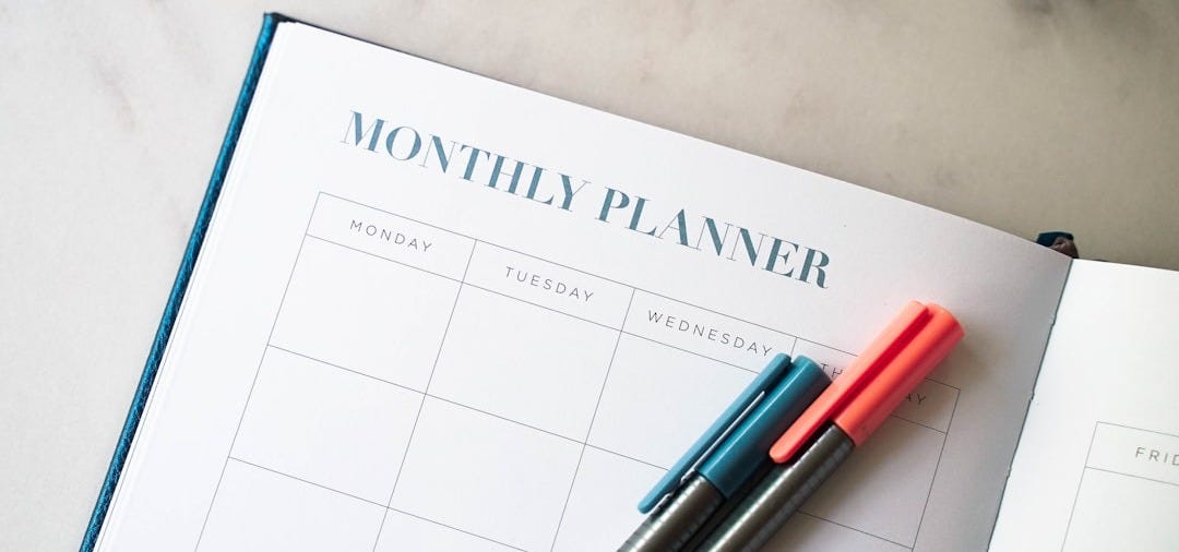 a planner with two pens sitting on top of it a planner with two pens sitting on top of it