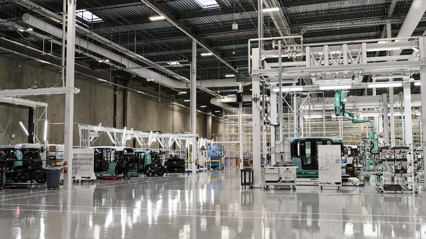 The facility, spanning 3.5 football fields, relies on a mix of human technicians and robots to assemble Zoox's bespoke vehicles.