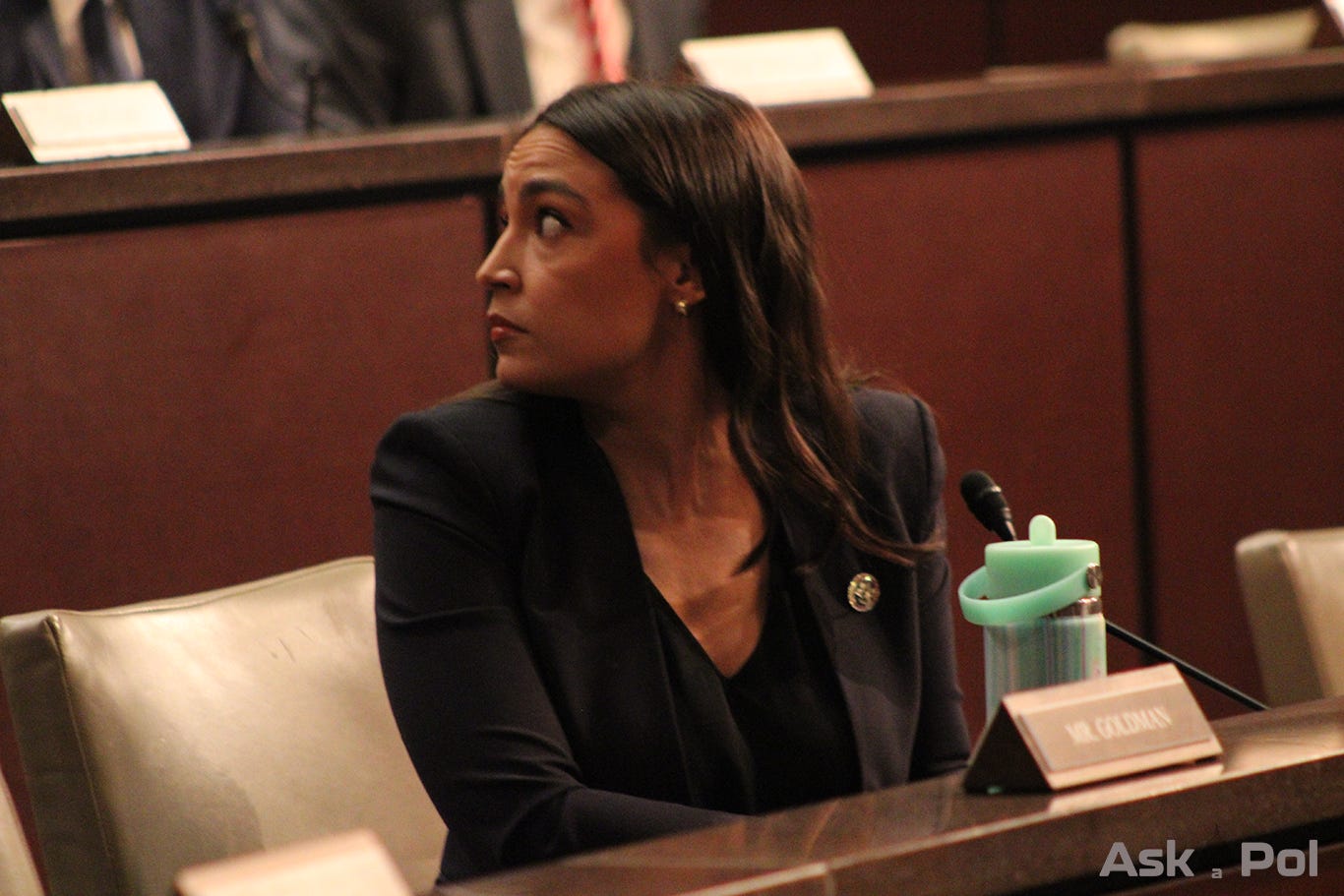 On dais Rep. Alexandria Ocasio-Cortez at a congressional hearing. Photo: Logan Johnson © AskaPol.com 