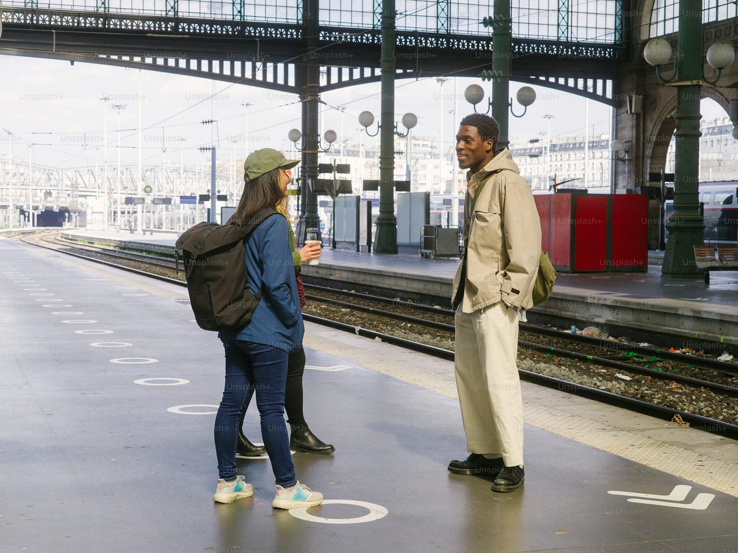 a man and a woman standing on a train platform a man and a woman standing on a train platform