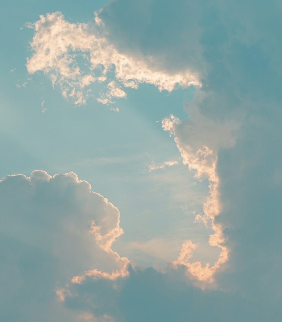 Golden light shines through soft clouds in the sky. Golden light shines through soft clouds in the sky.