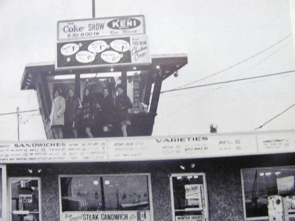 Anchorage, Alaska teens pose in front of the Coke Show radio booth on the roof of the Bun Drive-In.