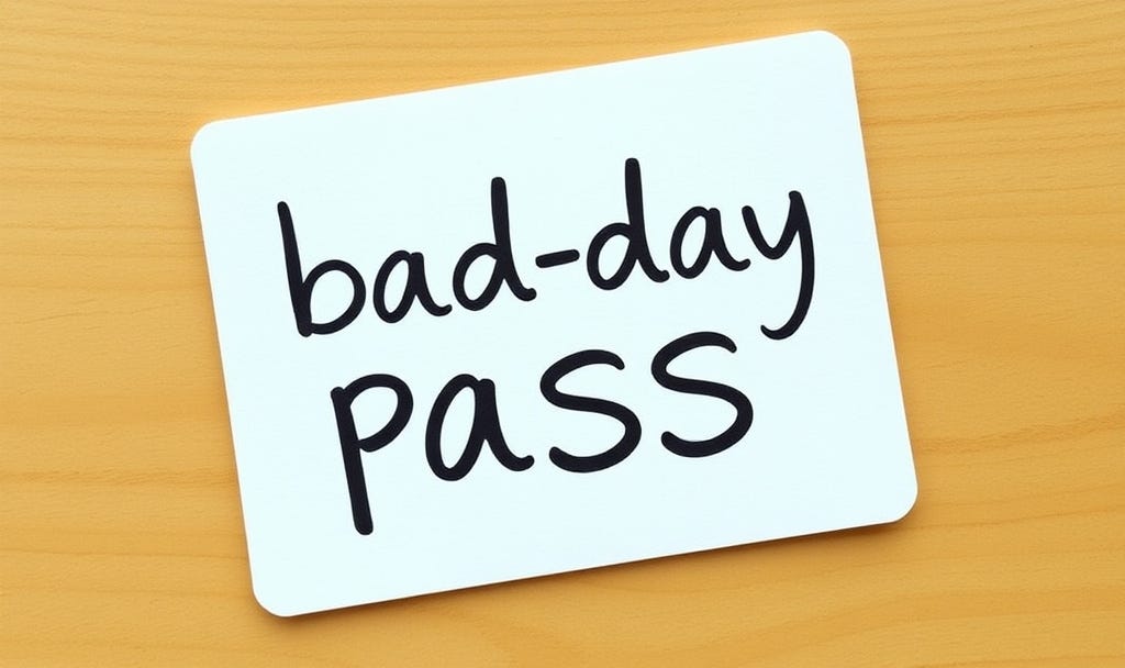 A white rectangular card says "bad-day" pass in black undercase letters. It sits on a light brown wooden surface.