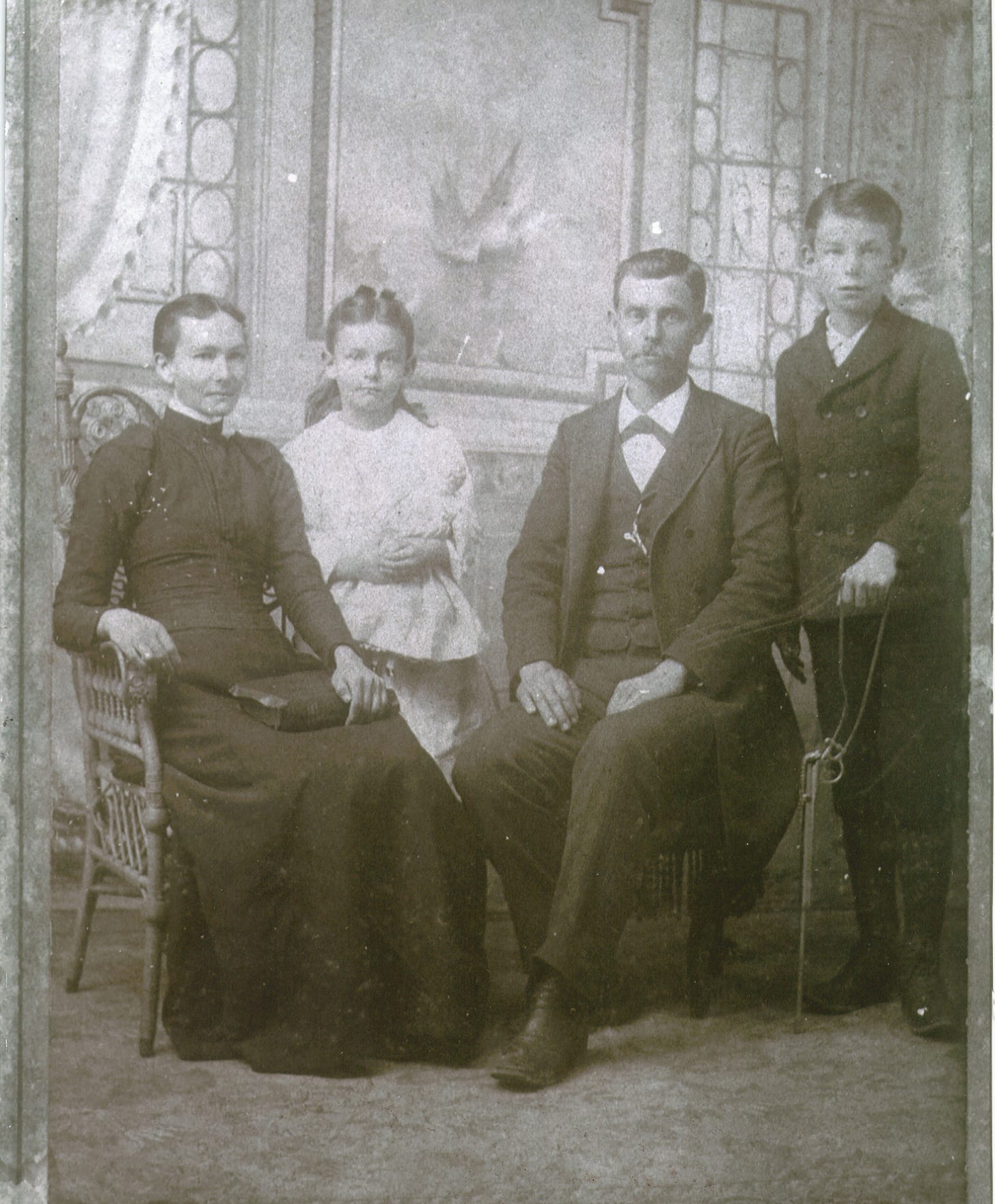 Studio portrait from around 1900 of the White family: Mother Elizabeth, daughter Mae at about age 10, father Robert, and son Ernest.