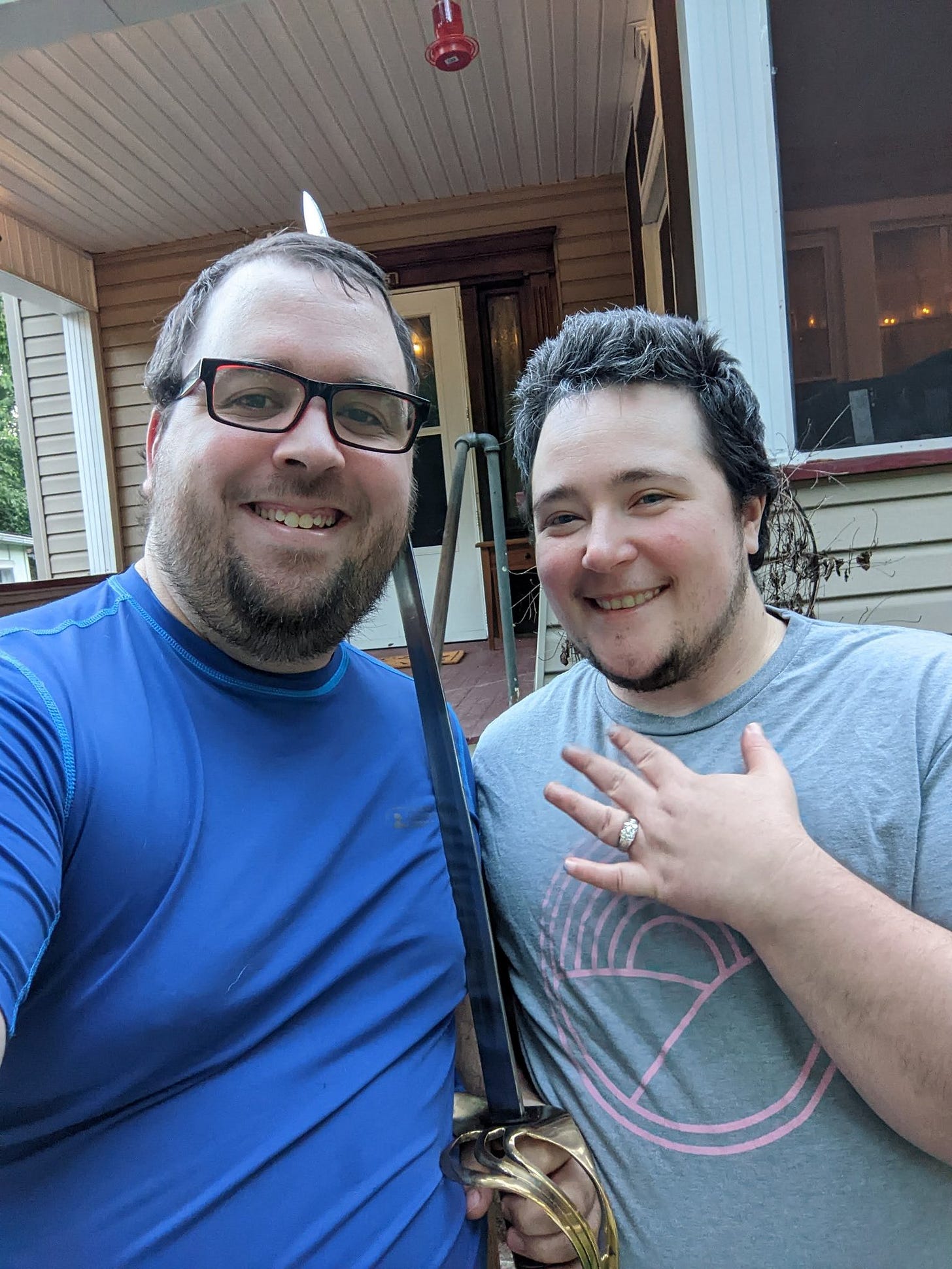 mcgravin and Grayson showing off his ring and holding a sword