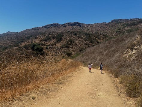 Photos of a desert hike featuring pictures of brown landscape, a waterfall, the author, a teepee, and a fence post with a quote on it.