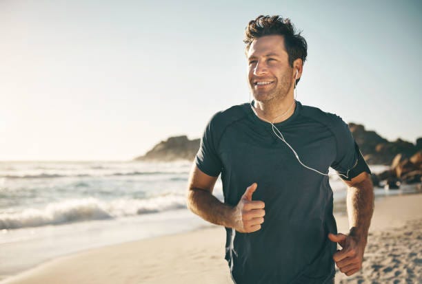 Active, fit and healthy man jogging on a beach while listening to music on earphones with stunning outdoor clear sky and sea copy space. Happy, mature and athletic guy running, doing fitness exercise Active, fit and healthy man jogging on a beach while listening to music on earphones with stunning outdoor clear sky and sea copy space. Happy, mature and athletic guy running, doing fitness exercise Man and the Beach stock pictures, royalty-free photos & images