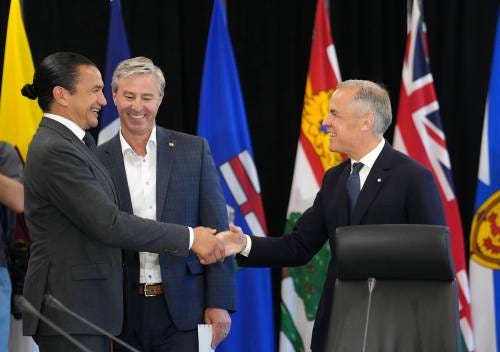 NATHAN DENETTE / THE CANADIAN PRESS
                                Prime Minister Mark Carney greets Manitoba Premier Wab Kinew as Nova Scotia Premier Tim Houston looks on, during the first ministers meeting in Huntsville, Ont., on Tuesday.