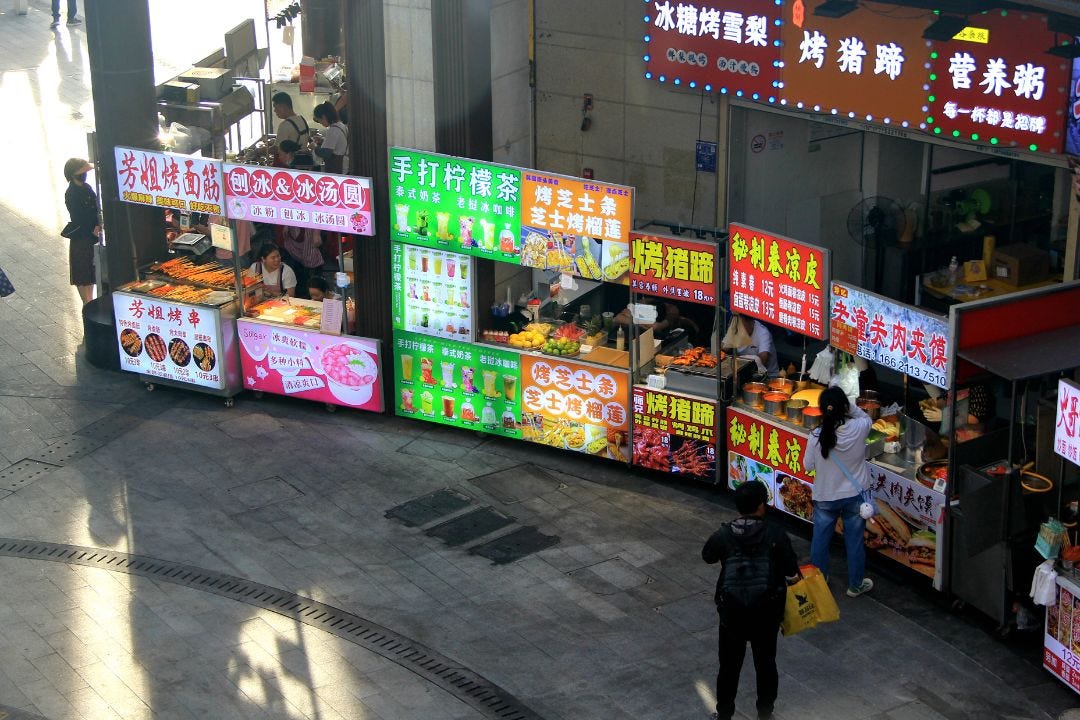 Vendors sell street food Thursday at a night market in Shanghai. Photo: VCG