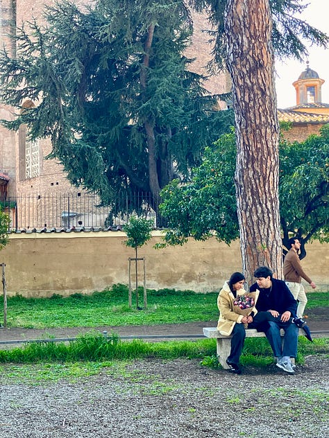 Una coppia è seduta vicina su una panchina in un parco, sotto un grande albero.  In un’altra immagine, due persone sono sedute su una panchina al sole mentre parlano e sorridono, con il prato alle spalle.  Nell’ultima, una coppia si abbraccia forte, davanti alla città.