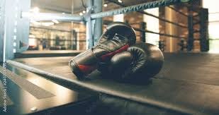 A pair of black boxing gloves lain ringside A pair of black boxing gloves lain ringside