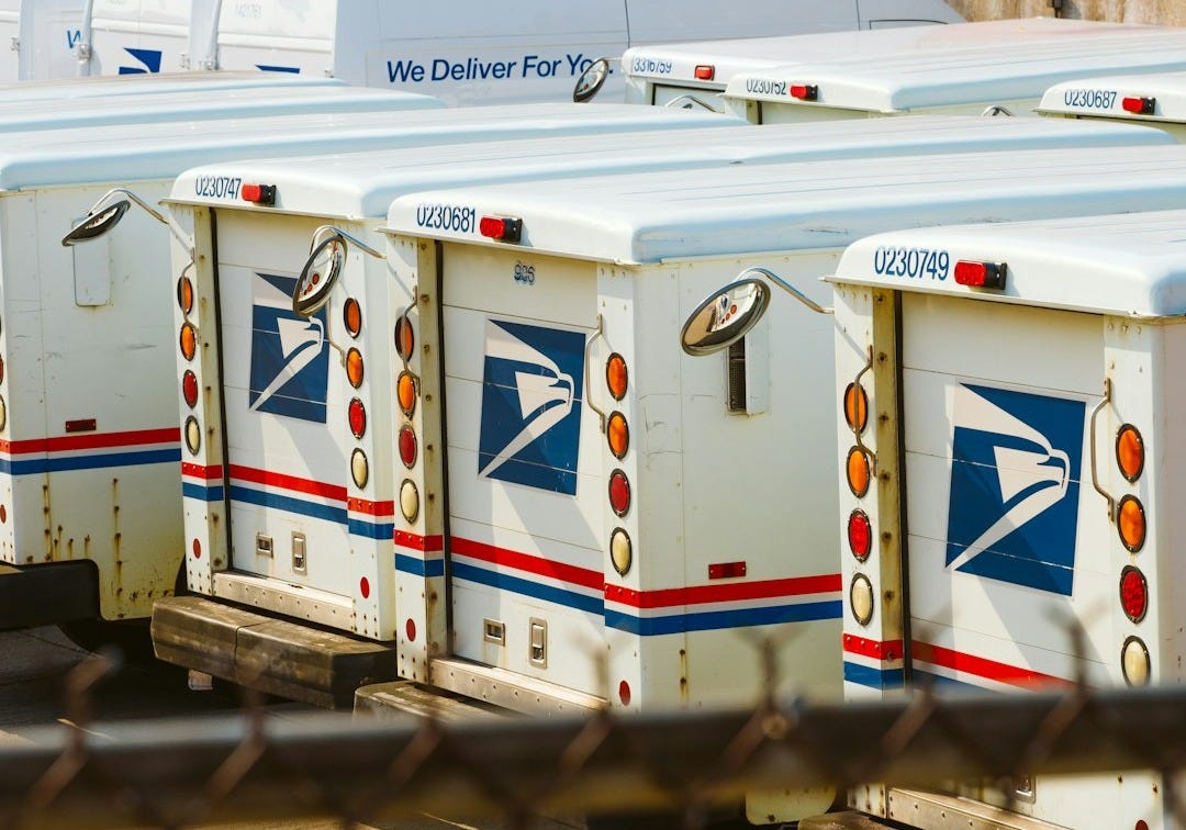 a row of mail boxes behind a chain link fence