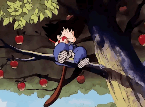This may contain: a boy sitting on a tree branch with an apple in his hand and apples hanging from the branches