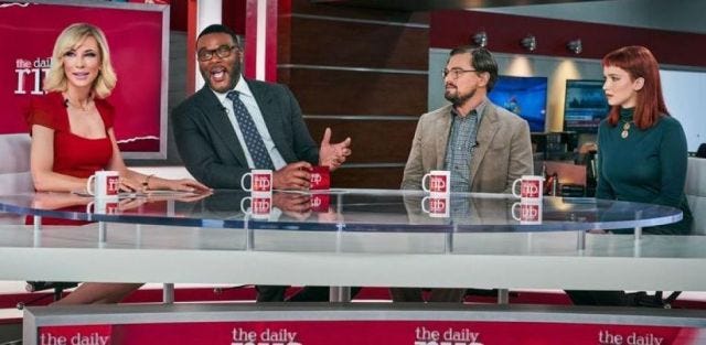 Scene from Don't Look Up where two cheery daytime talkshow hosts are making light of the serious topic two scientists, seated opposite them, are bringing to the show. Scene from Don't Look Up where two cheery daytime talkshow hosts are making light of the serious topic two scientists, seated opposite them, are bringing to the show.