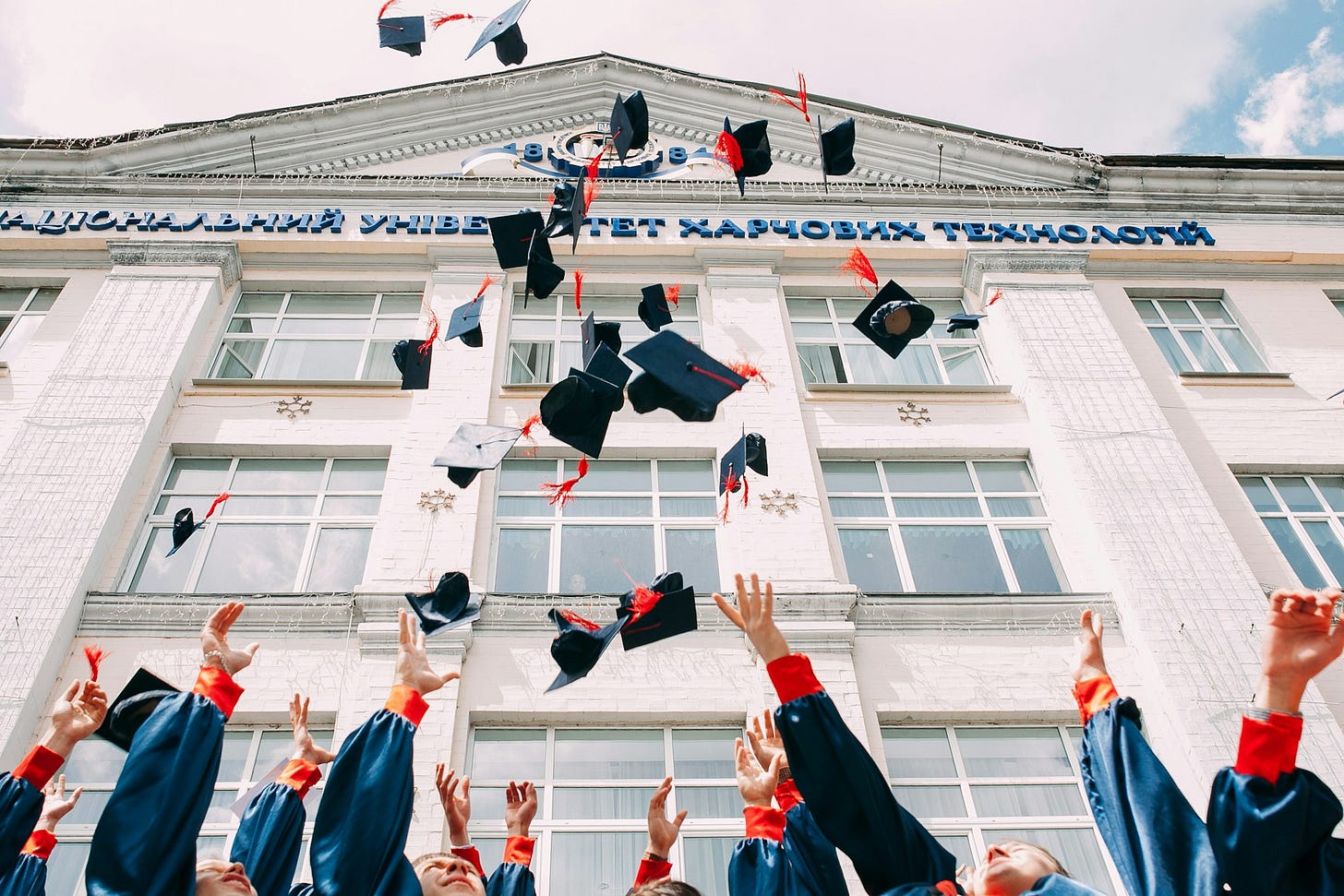 group of fresh graduates students throwing their academic hat in the air group of fresh graduates students throwing their academic hat in the air