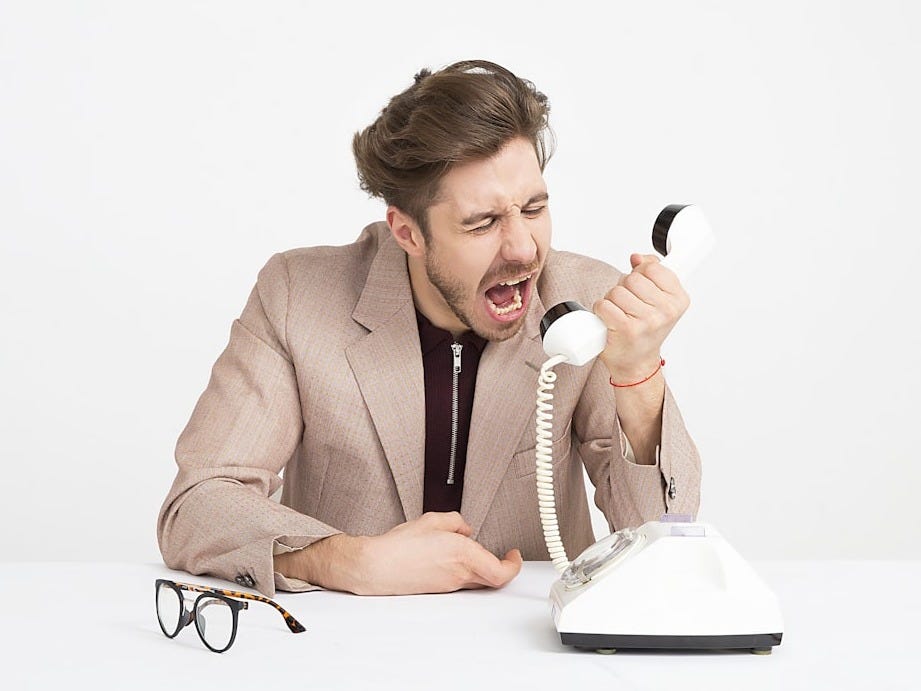 man holding telephone screaming