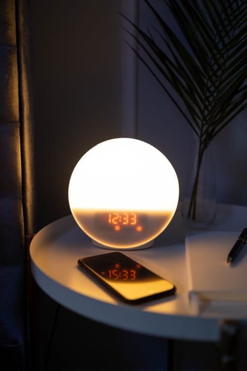 Free Alarm Clock and Phone on a Side Table Stock Photo