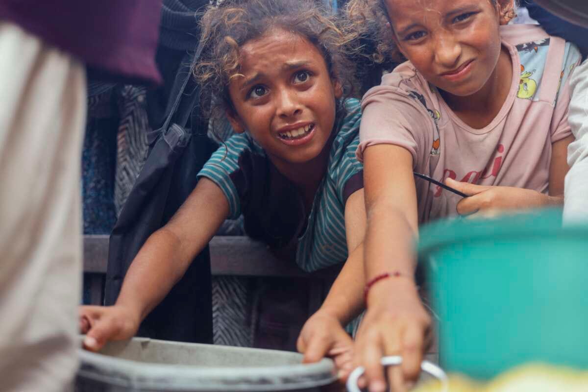 Displaced Palestinians wait in long lines for a charitable meal under crowded tents in Khan Yunis, Gaza, on October 21, 2025, as food scarcity worsens under Israel’s ongoing siege.