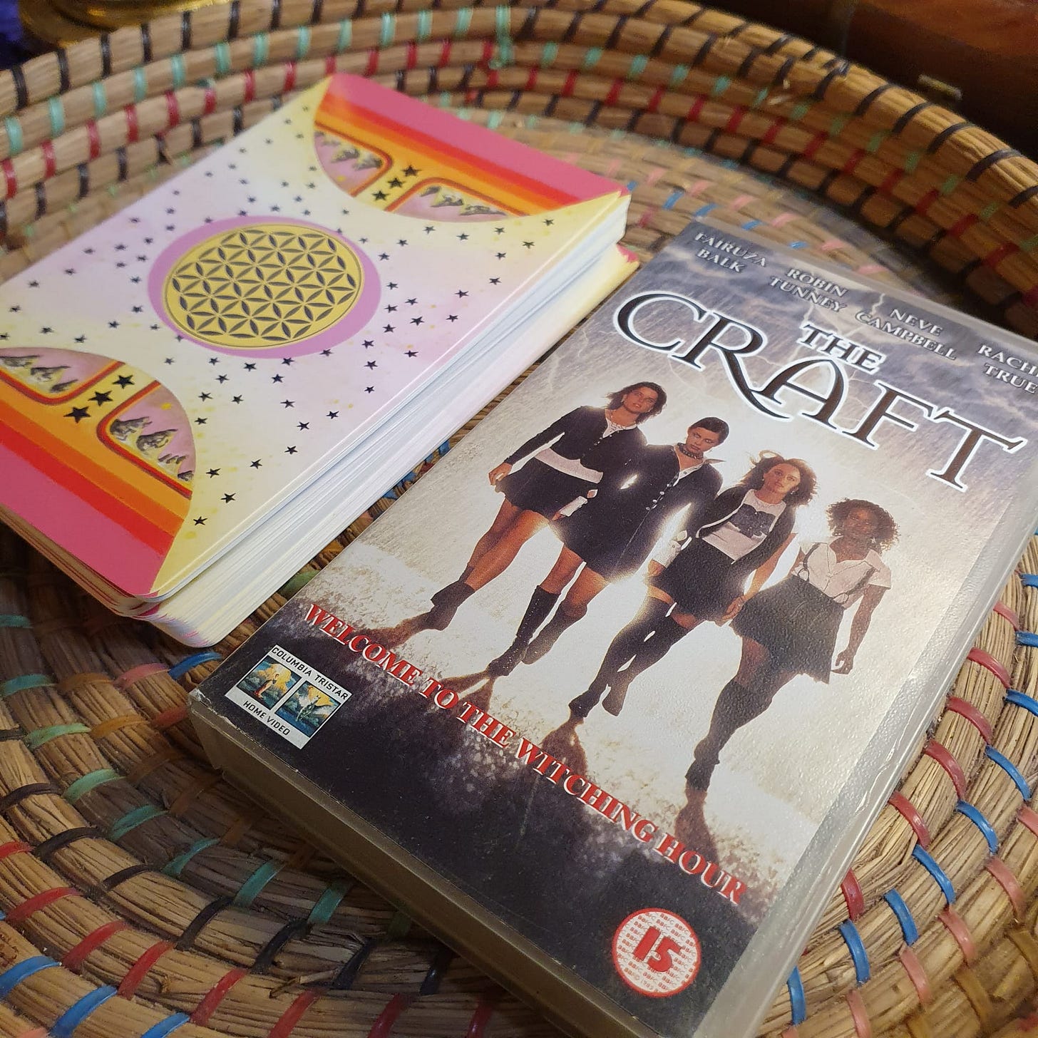 A picture of The Craft VHS cassette beside a deck of tarot cards for scale