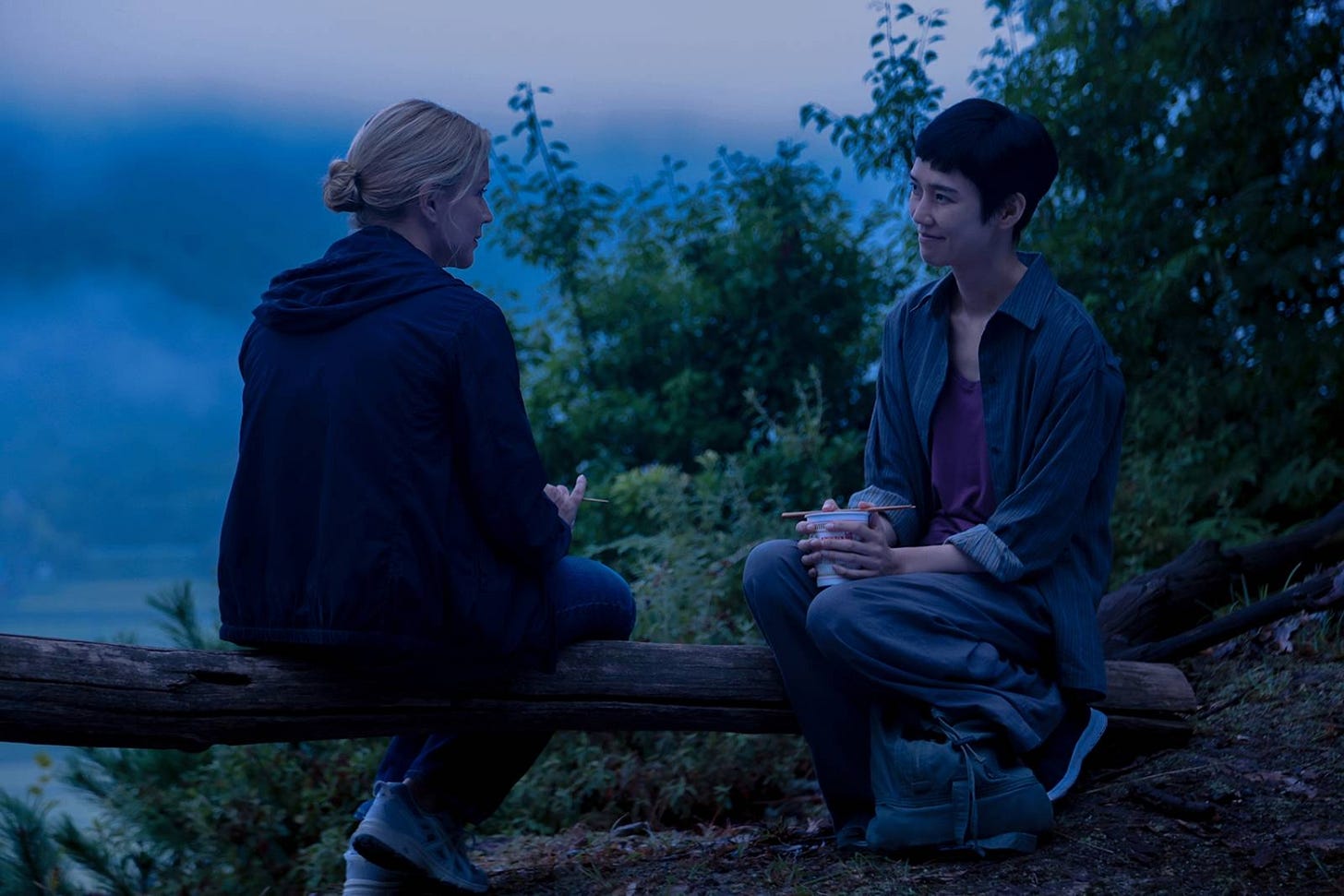 Virginie Efira and Tao Okamoto seated together outdoors in a scene from Ryūsuke Hamaguchi's All of a Sudden. Virginie Efira and Tao Okamoto seated together outdoors in a scene from Ryūsuke Hamaguchi's All of a Sudden.