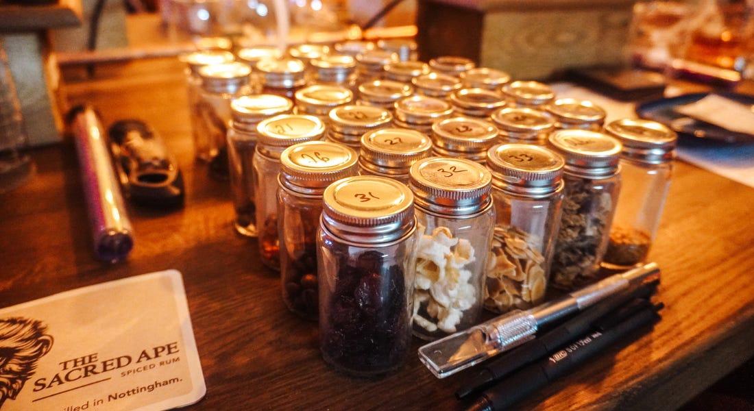 A wooden table with jars with silver lids on it A wooden table with jars with silver lids on it