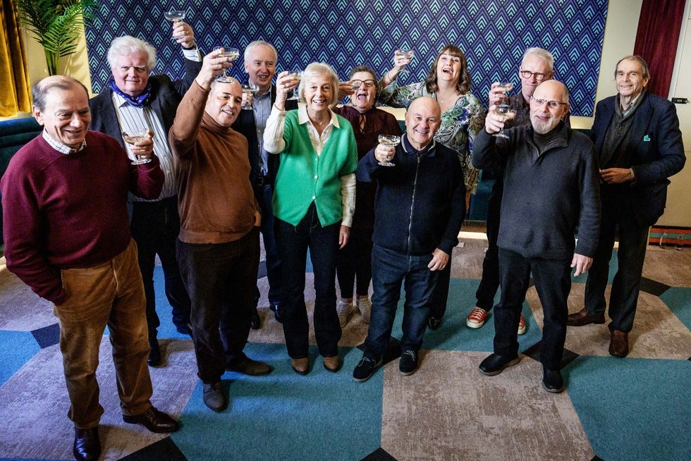 John, Bruce, Symon, Andrew, Suzy, Jackie, Tony, Sue, Peter, Paul and Neil all stood alongside one another raising a glass.