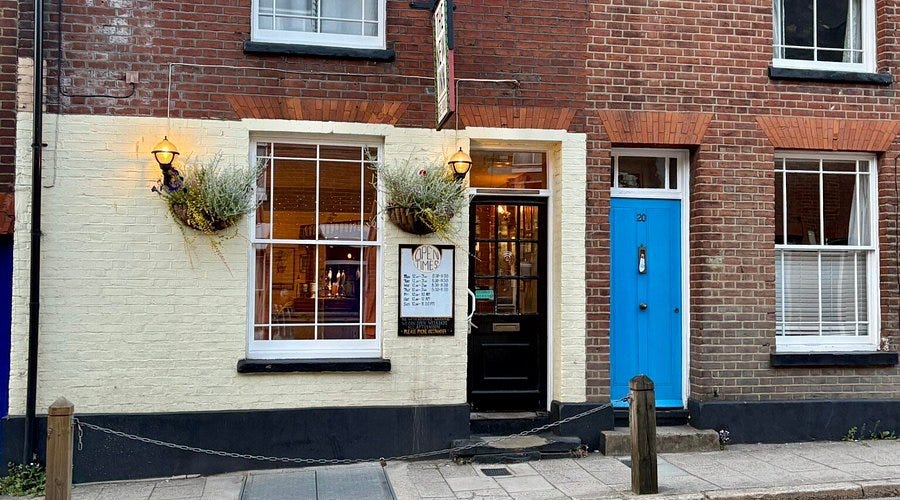 Outside the New Inn from the street - looks like an old terraced house, hanging baskets and a small sign are the only giveaway that it isn't