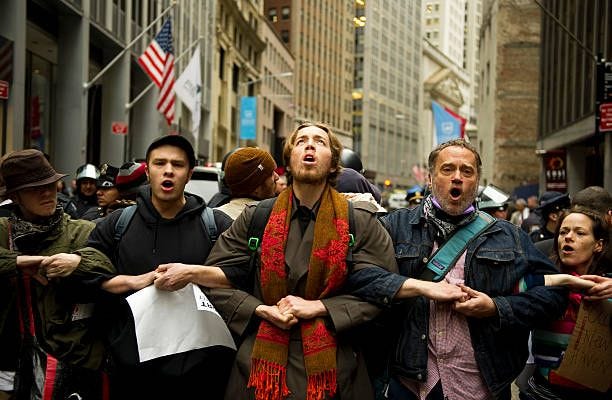 Occupy Wall Street protestors lock arms and block access to the New York Stock Exchange area November 17, 2011 in New York. Some 1,000 protesters...