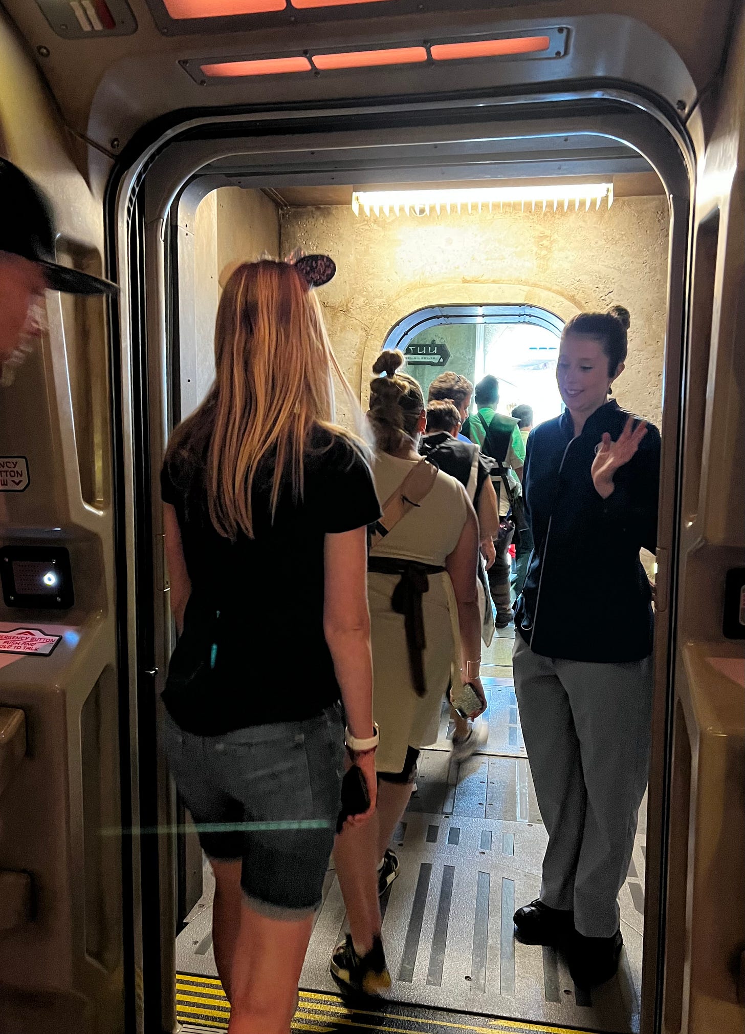 A doorway heading to the outside, with a line of people exiting