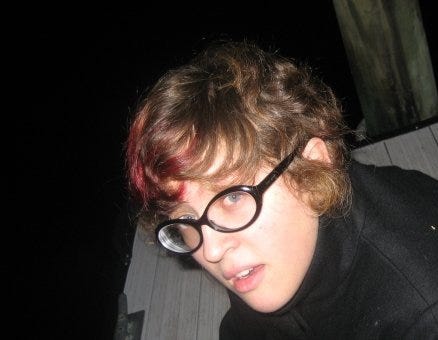 Krys as a nonbinary teen sitting on a dock at night