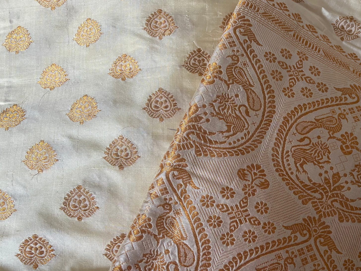Detailed close-up of an Assamese mekhela sador made from paat (mulberry silk). Traditional hingkhap motifs and delicate buta motifs are woven into the fabric, emphasizing its fine texture, natural sheen, and intricate craftsmanship. Detailed close-up of an Assamese mekhela sador made from paat (mulberry silk). Traditional hingkhap motifs and delicate buta motifs are woven into the fabric, emphasizing its fine texture, natural sheen, and intricate craftsmanship.