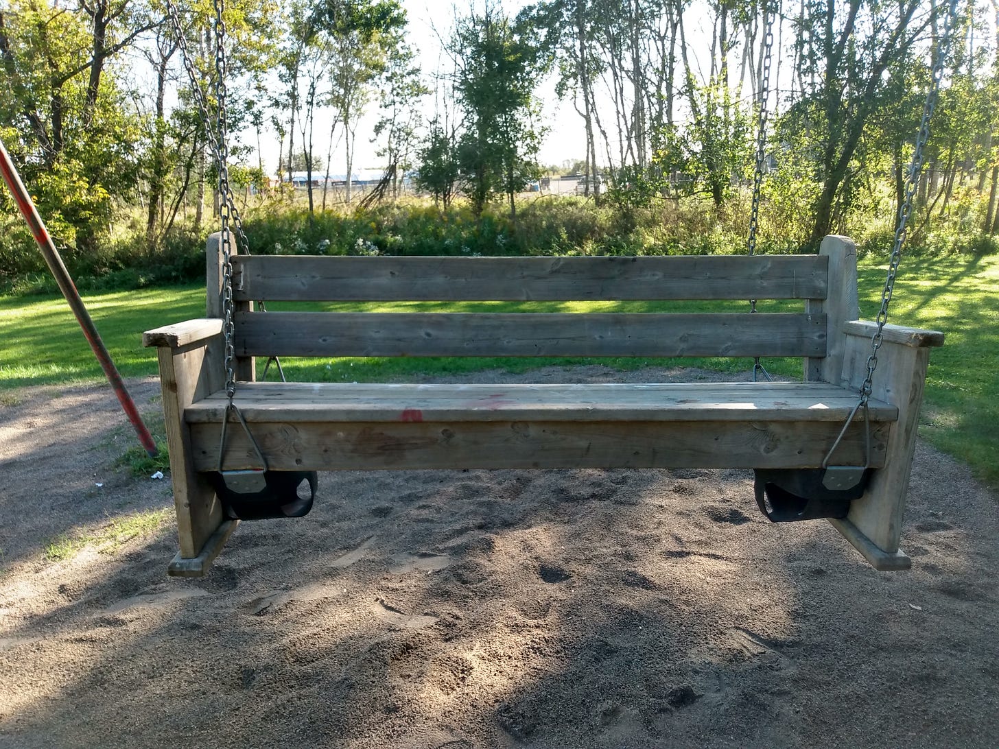 a photo of a park bench that has been hoisted up onto some swings by some local anonymous pranksters a photo of a park bench that has been hoisted up onto some swings by some local anonymous pranksters