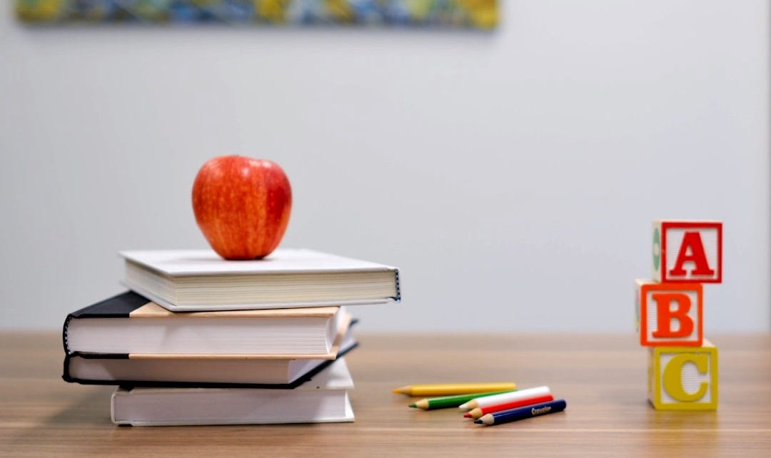 red apple fruit on four pyle books