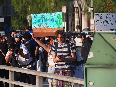 Protesters begin vandalizing police vehicles that are parked on the 101 freeway.