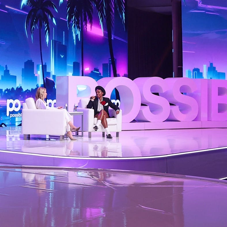 A person sitting in a chair on a stage with a microphone

AI-generated content may be incorrect.