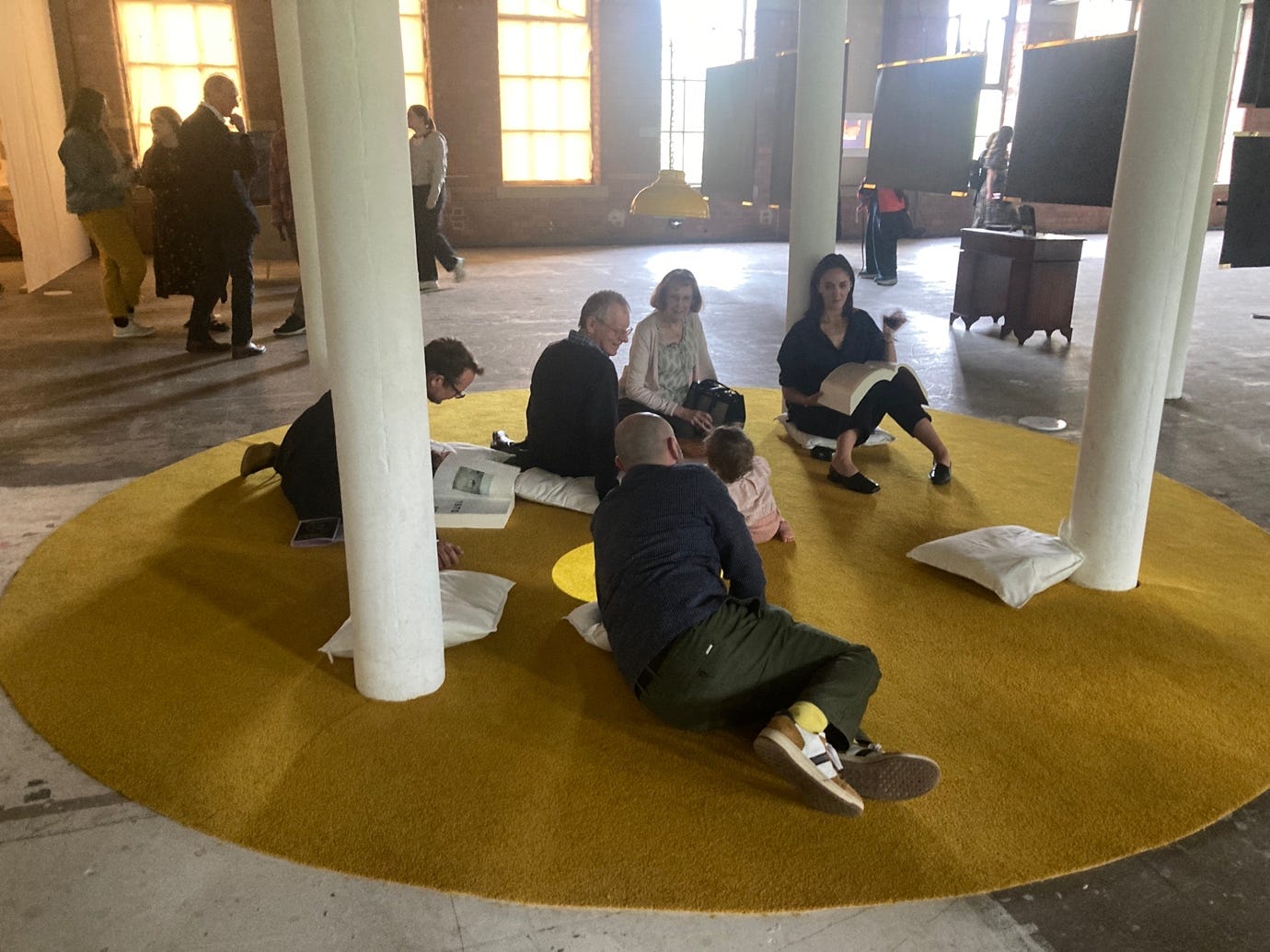 A group of people sitting on a yellow carpet

AI-generated content may be incorrect.