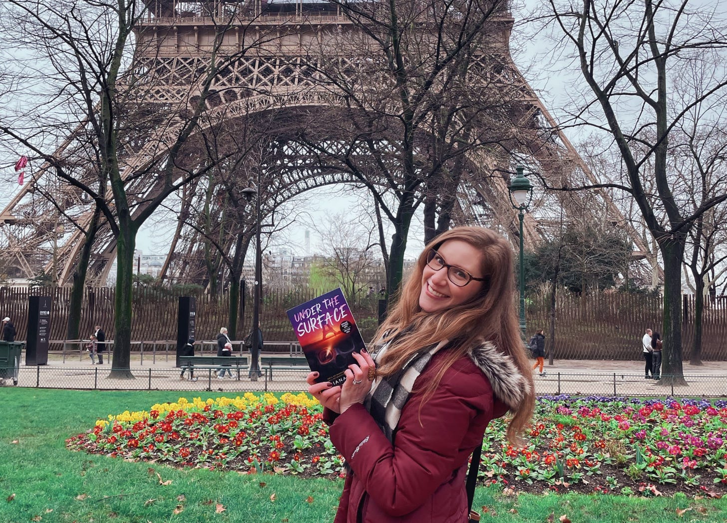 Diana Urban with her book Under the Surface in Paris in front of the Eiffel Tower
