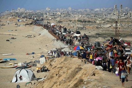 Displaced Palestinians carry their belongings south on a road near the Nuseirat refugee camp in central Gaza, following renewed Israeli evacuation orders for Gaza City, yesterday.