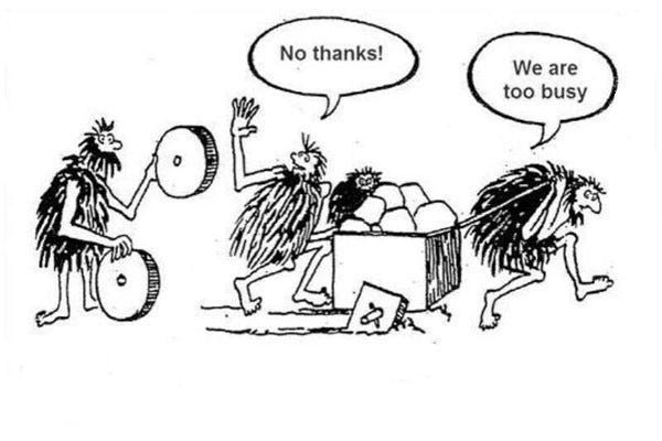 picture of 3 cavemen. one holding round shaped wheels made of stone with a suggestive look towards the other two who are moving a cart with square shaped wheels. One of them says “no thanks”. The other says “we are too busy”.