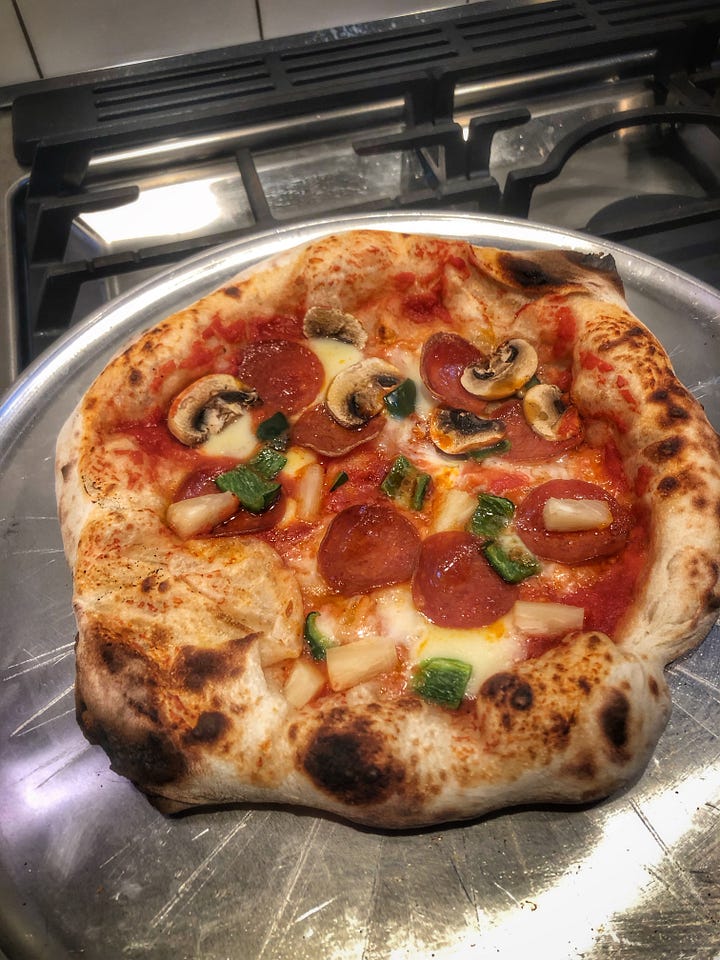 Two photos of pizzas with pepperoni, green onion, mushroom, and pineapple on a metal tray. The pizza on the left is small and misshapen with a thick, doughy crust. The pizza on the right covers almost the entire tray and has a much more proportional crust.