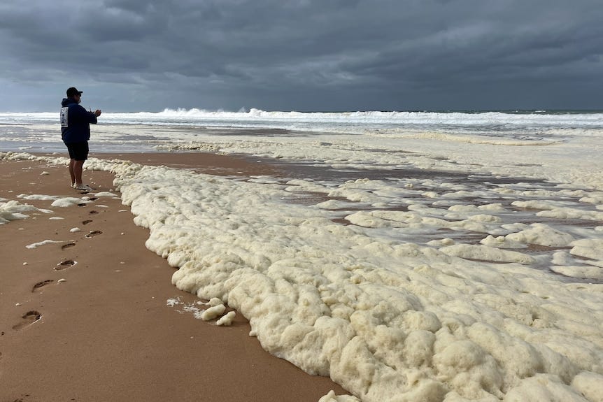 A large build up on cloud like foam on a beach. 