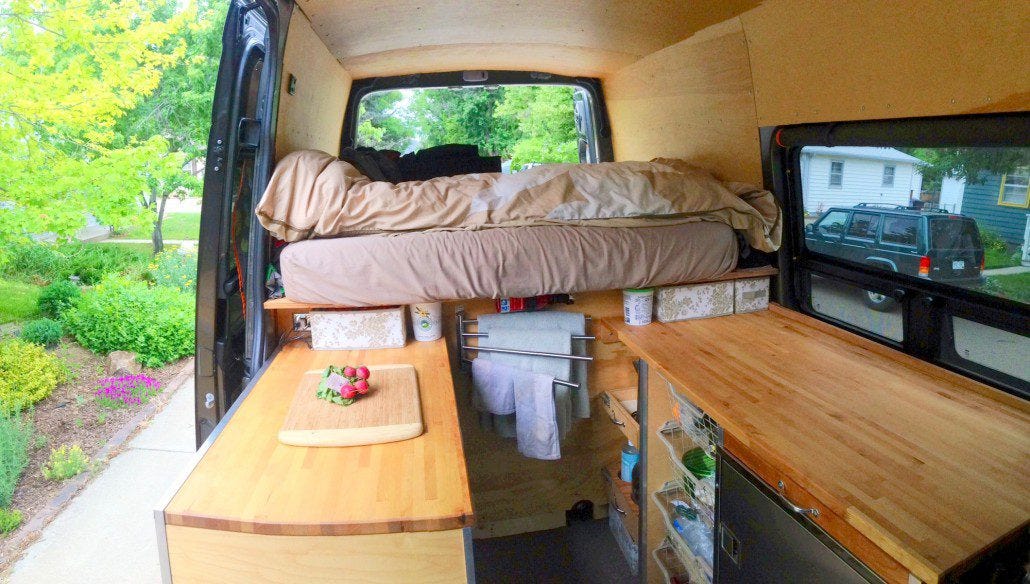 View in Sprinter van sitting in front swivel seat looking back. Ikea countertops on either side, utility drawer over fridge on drivers side, and storage with wire baskets underneath the countertops. View in Sprinter van sitting in front swivel seat looking back. Ikea countertops on either side, utility drawer over fridge on drivers side, and storage with wire baskets underneath the countertops.