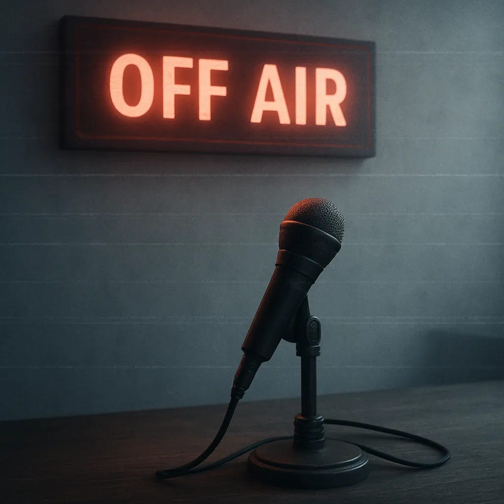 A flowing off air sign behind a single unplugged mic