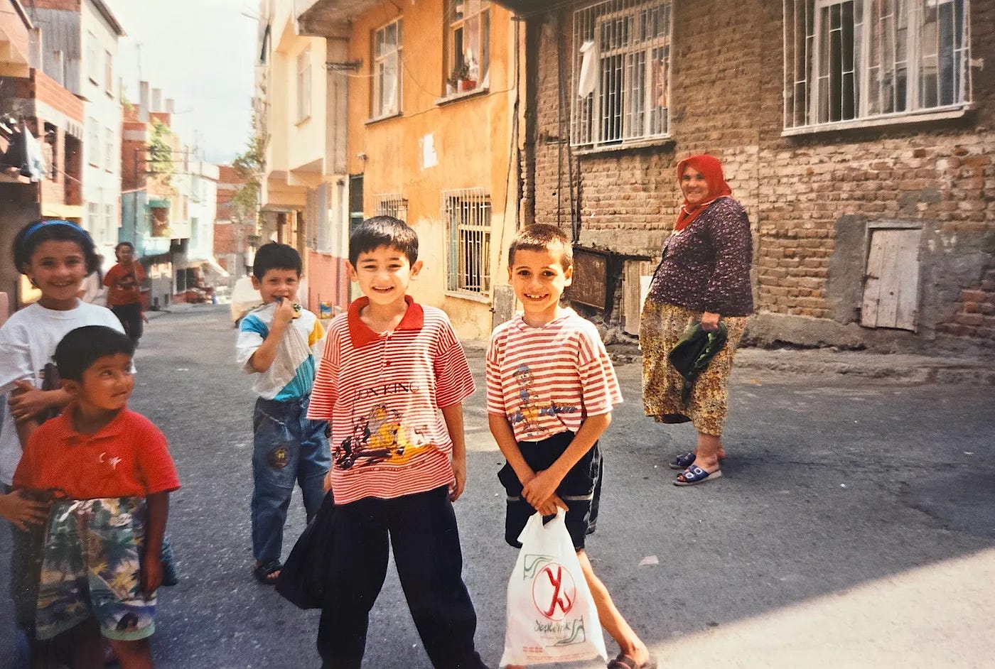 Children playing and a smiling woman in the street in Turkey