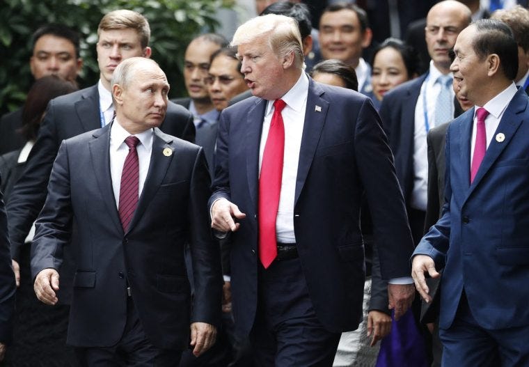 US President Donald Trump (C) and Russia's President Vladimir Putin talk as they make their way to take the "family photo" during the Asia-Pacific Economic Cooperation (APEC) leaders' summit in the central Vietnamese city of Danang on November 11, 2017. World leaders and senior business figures are gathering in the Vietnamese city of Danang this week for the annual 21-member APEC summit. (Photo by JORGE SILVA / POOL / AFP) (Photo by JORGE SILVA/POOL/AFP via Getty Images) US President Donald Trump (C) and Russia's President Vladimir Putin talk as they make their way to take the "family photo" during the Asia-Pacific Economic Cooperation (APEC) leaders' summit in the central Vietnamese city of Danang on November 11, 2017. World leaders and senior business figures are gathering in the Vietnamese city of Danang this week for the annual 21-member APEC summit. (Photo by JORGE SILVA / POOL / AFP) (Photo by JORGE SILVA/POOL/AFP via Getty Images)