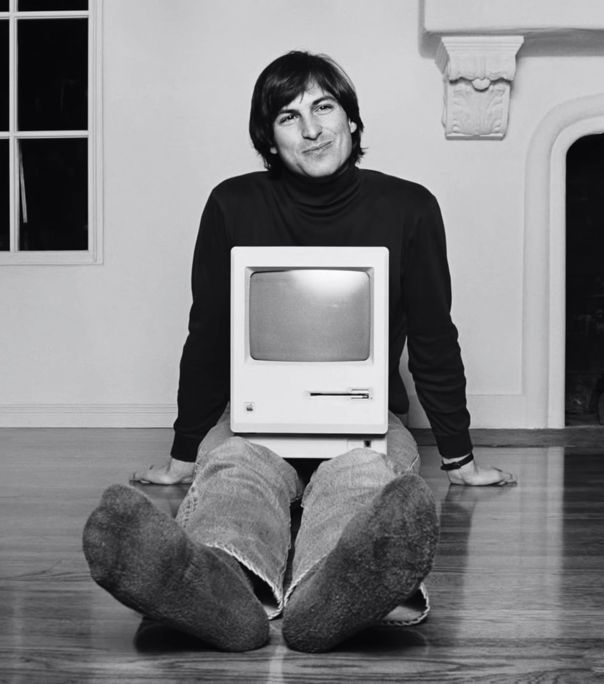 A person sitting on the floor with a computer monitor

Description automatically generated