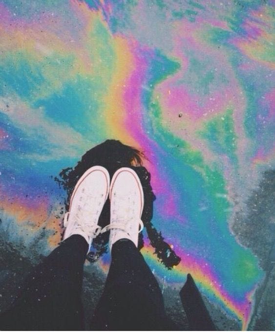 This may contain: the person is standing in front of a colorful painting on the ground with their feet up