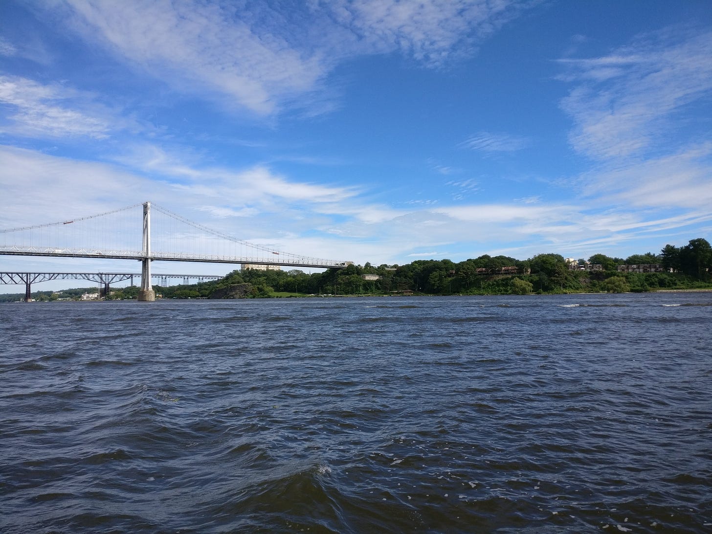 A picture of the two bridges in Poughkeepsie taken from the water. You can see we're in the middle of the river and the shoreline is just a line of indistinct greenery A picture of the two bridges in Poughkeepsie taken from the water. You can see we're in the middle of the river and the shoreline is just a line of indistinct greenery