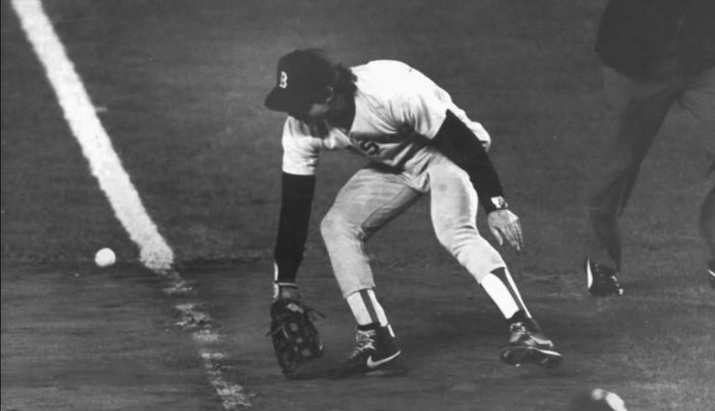 A baseball player in a catching position is preparing to catch a pitch.